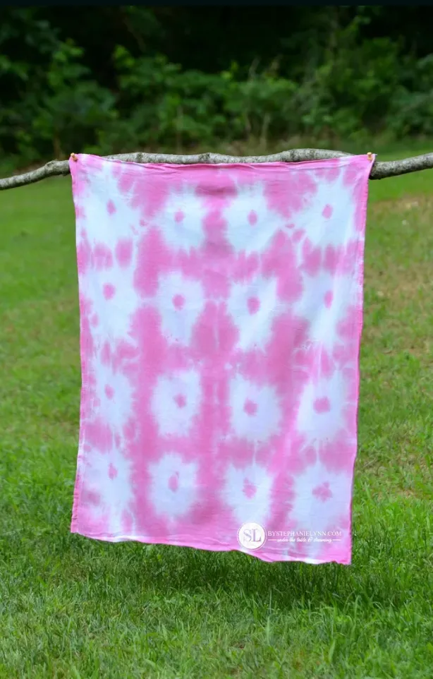 Sunburst pink Tie Dye on a sheet hanging in a field