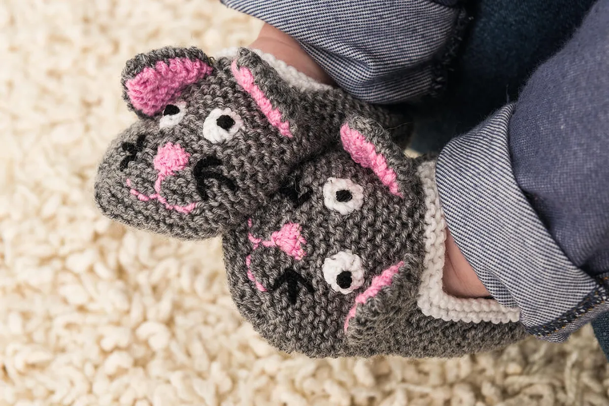 this free knitting pattern for baby booties uses two needles and has the face of a cat on each bootie