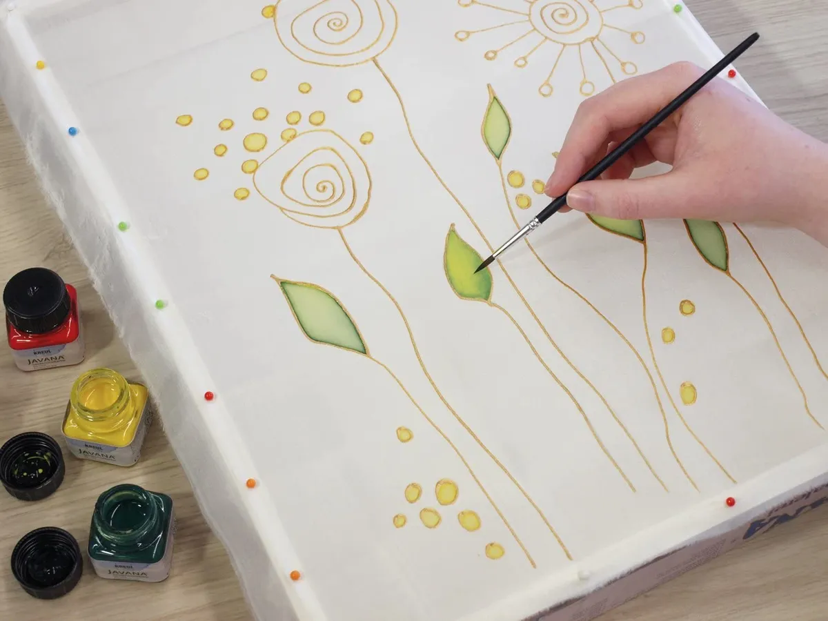 Once the Gutta outlines are dry, paint your designs using silk paint.