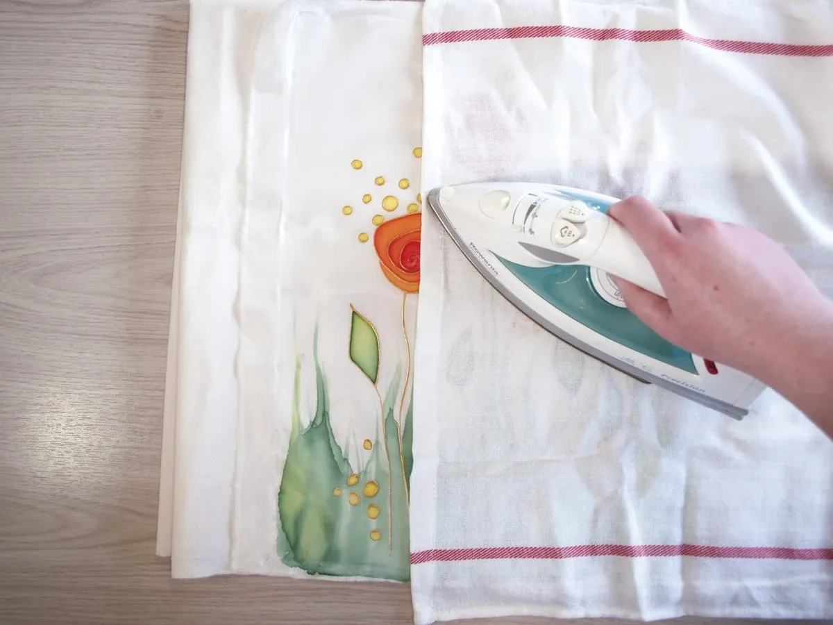 Fix your design by ironing on a low heat. Use a tea towel between the silk and the iron so that you're not ironing directly onto the silk.