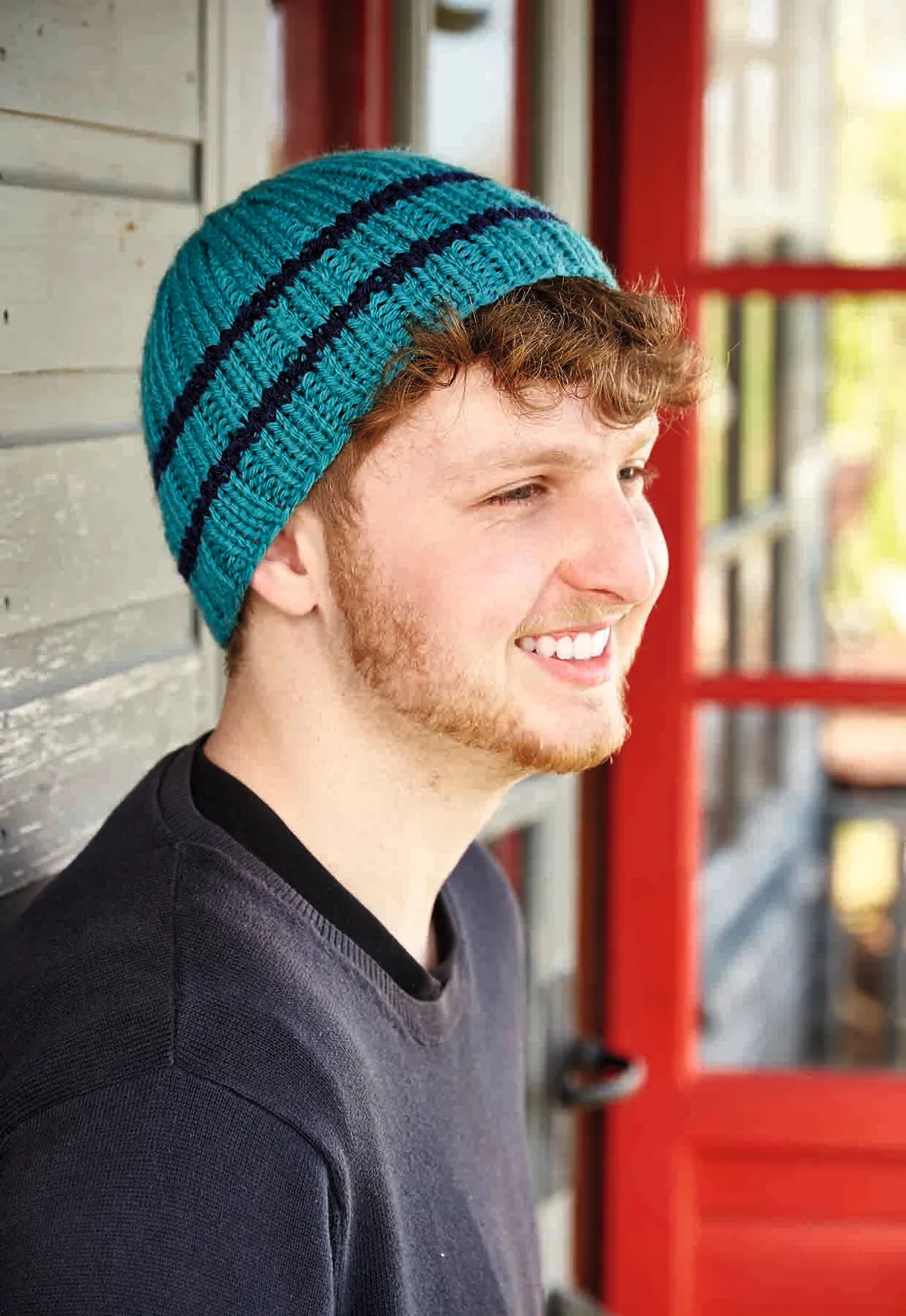 the beanie hat knitting pattern is worn by a young man with red hair and a big smile