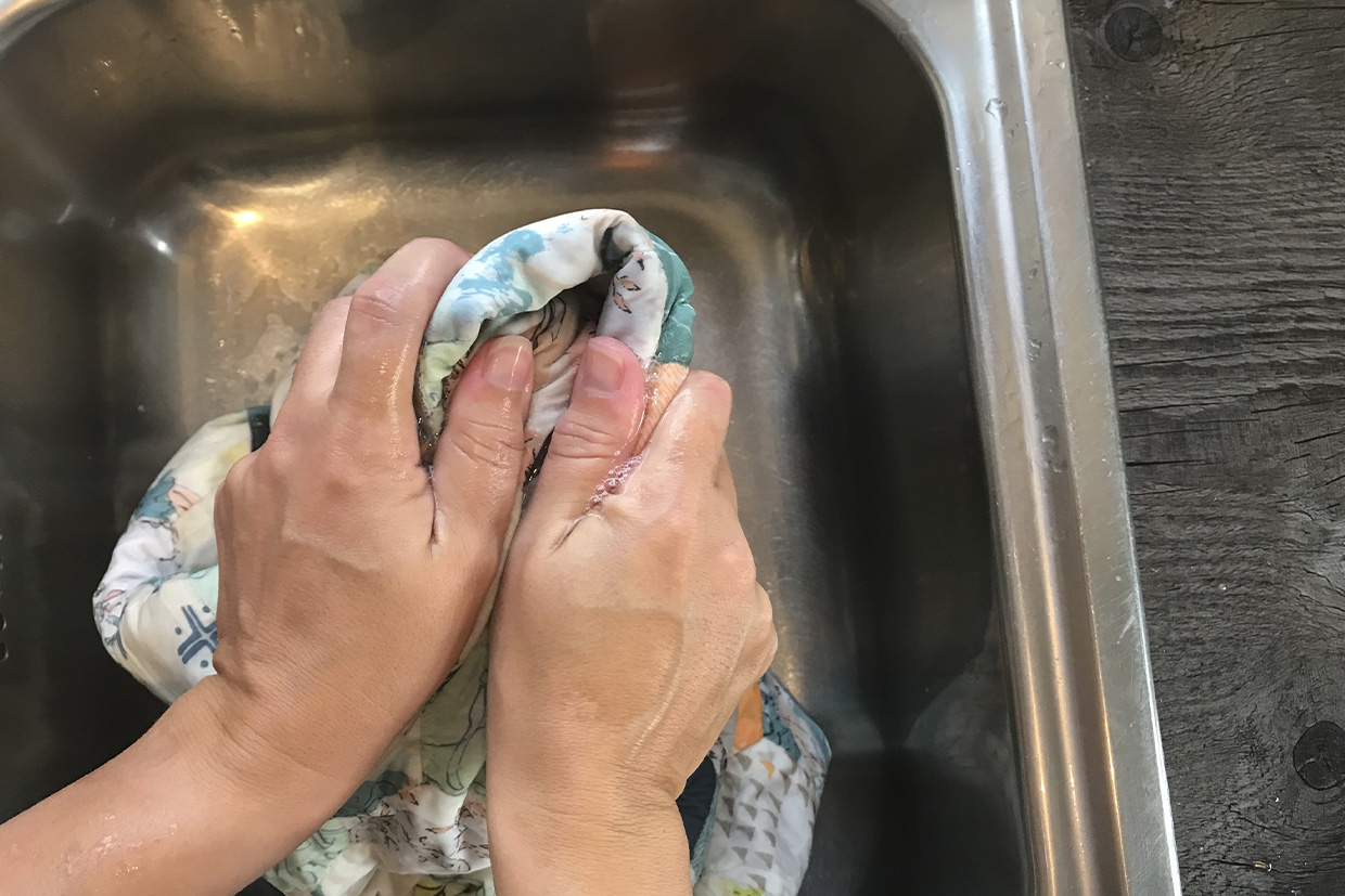 Squeezing a washed quilt in a sink by hand