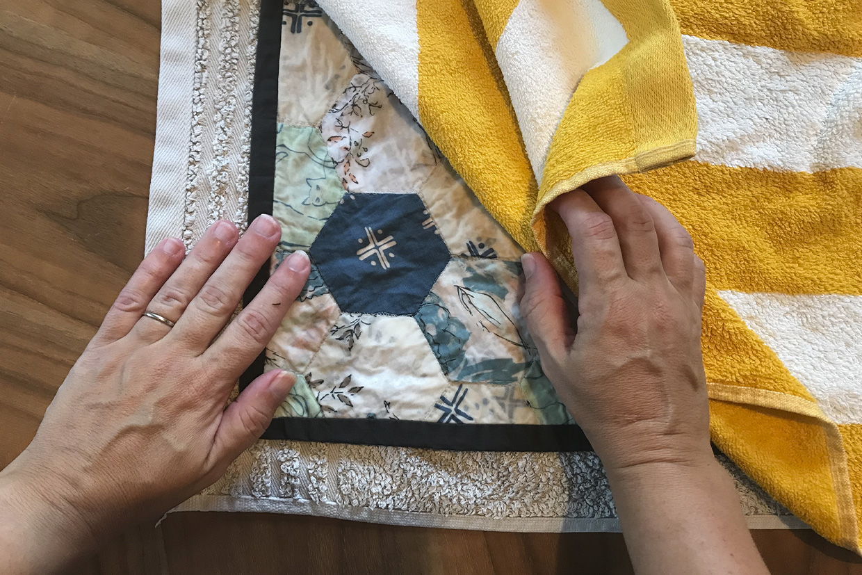 Drying a handmade quilt with a towel