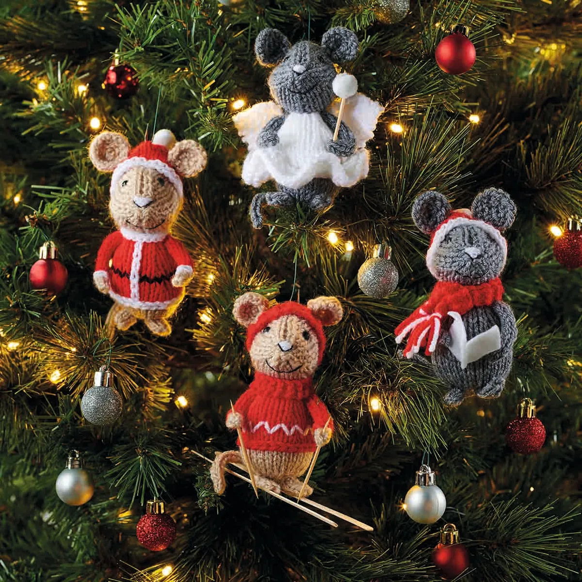 This is a full portrait picture showing all 4 christmas mice hanging from a tree decked with fairy lights and silver and red glitter baubles