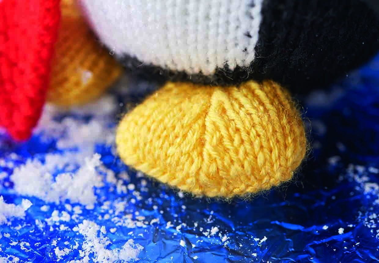 the penguins free are knitted in pale orange yarn