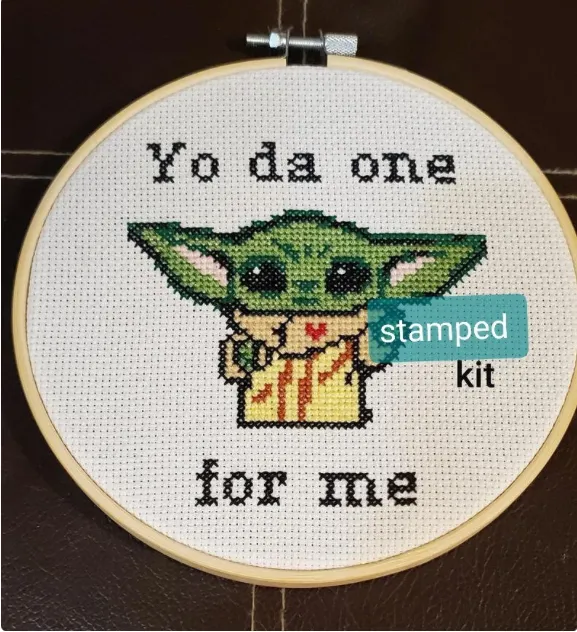 A cross stitched image of baby yoda has the wording yoda one for me around it