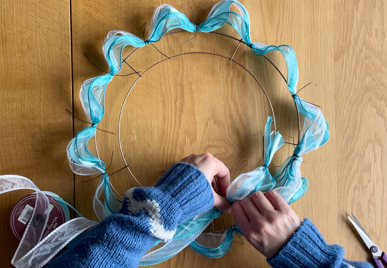 Adding the second circle of ribbons to the ribbon wreath