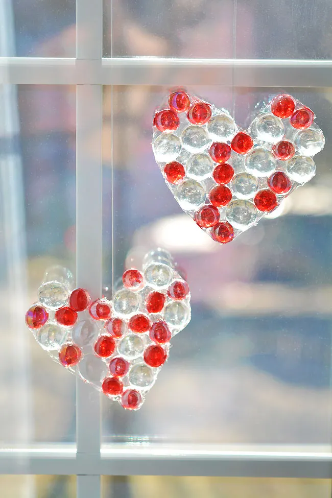 Two hearts hanging in a window made from glass beads - valentines crafts for kids