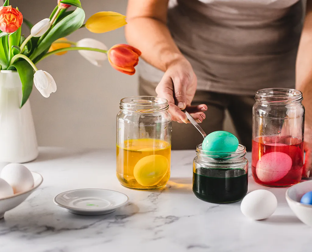 Woman dyeing Easter eggs at home