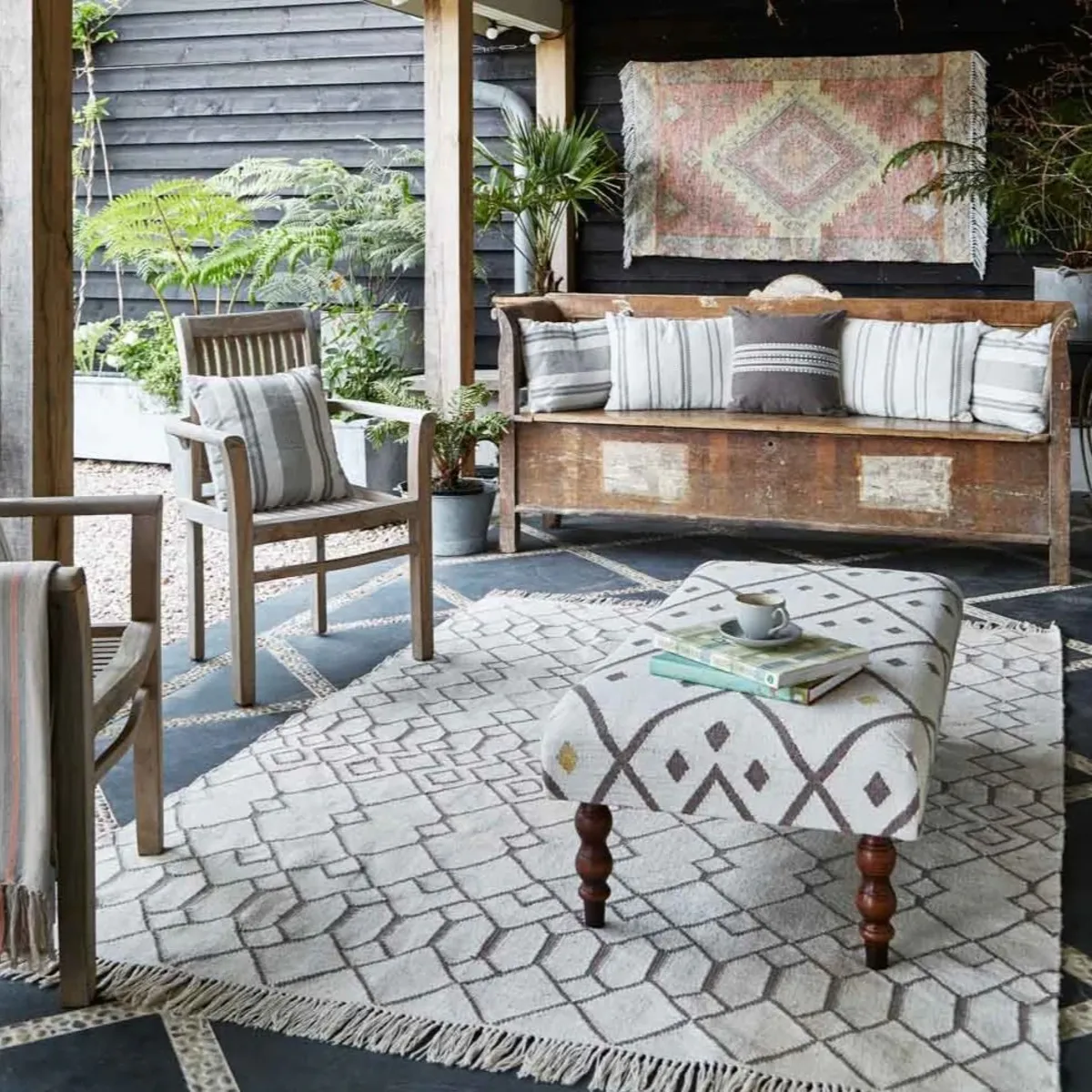 Outdoor room set up with rug, ottoman, sofa and chairs