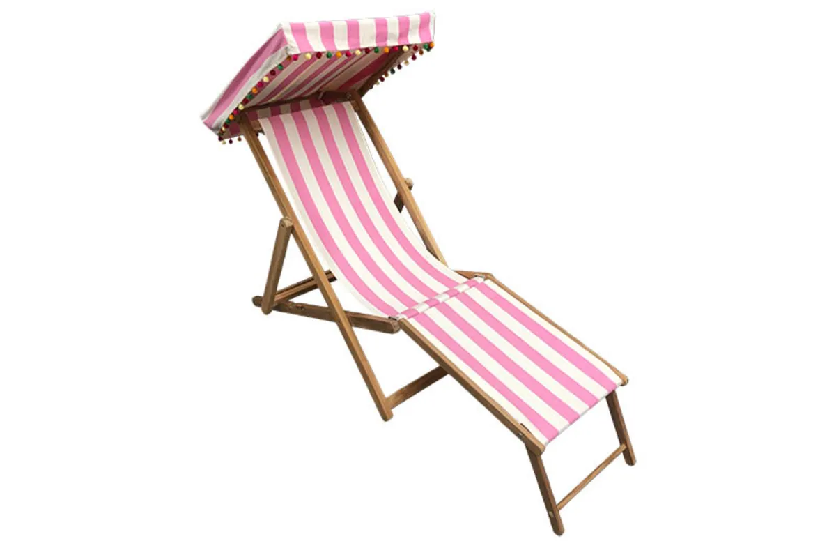 Pink and white striped deckchair with pom pom-edged canopy