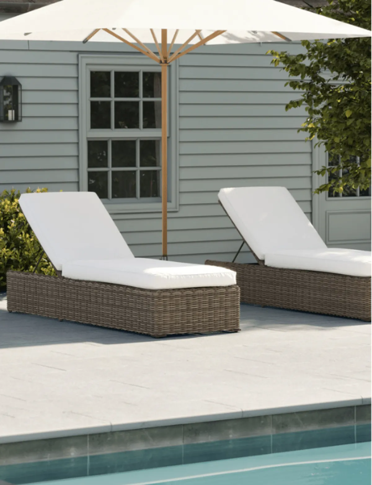 Two rattan pool loungers with thick white cushions