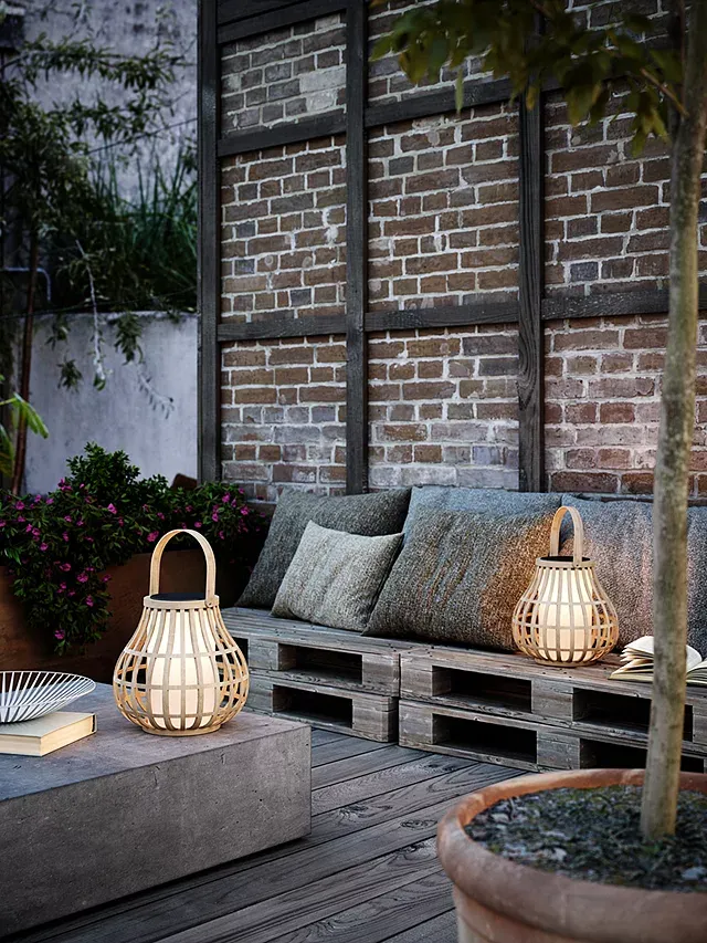 Portable LED lanterns on a table and sofa outdoors