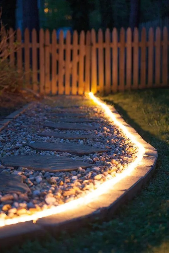 Rope light lit up along a garden path at night