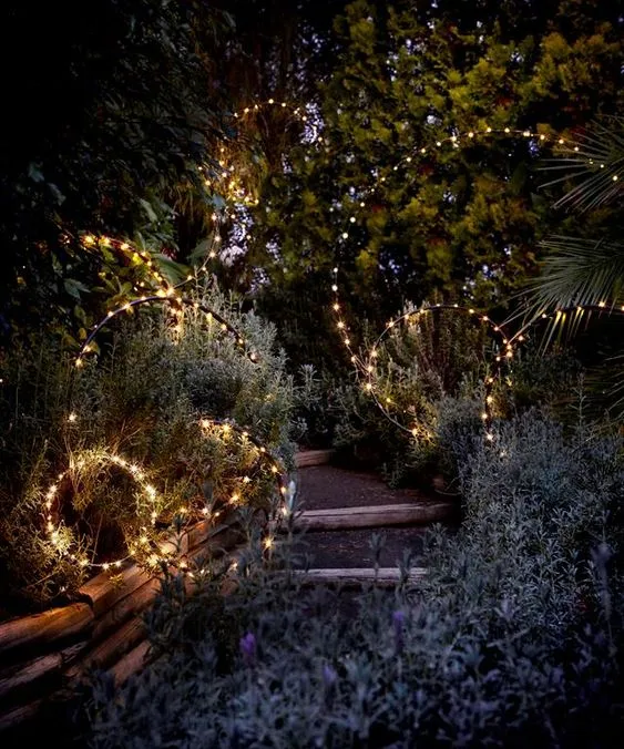 Illuminated circles arranged along a garden path at night