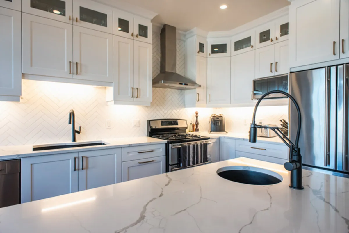 A modern white kitchen with white quartz worktop