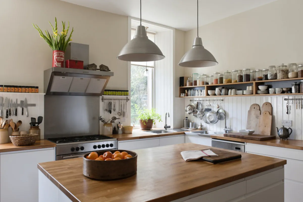 A country-style kitchen with island and dark wooden worktops