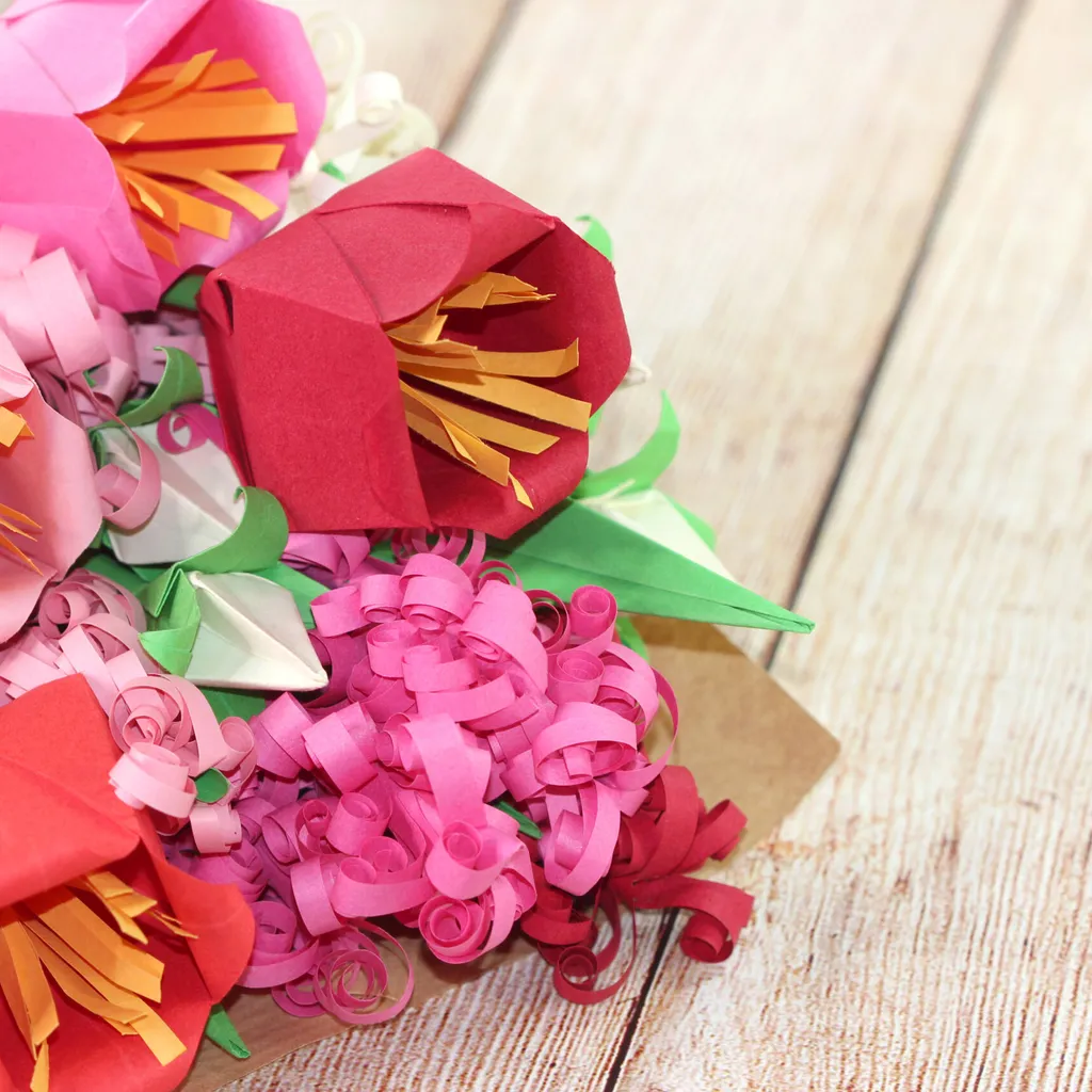 A range of colourful flowers in an origami flower bouquet on a wooden table