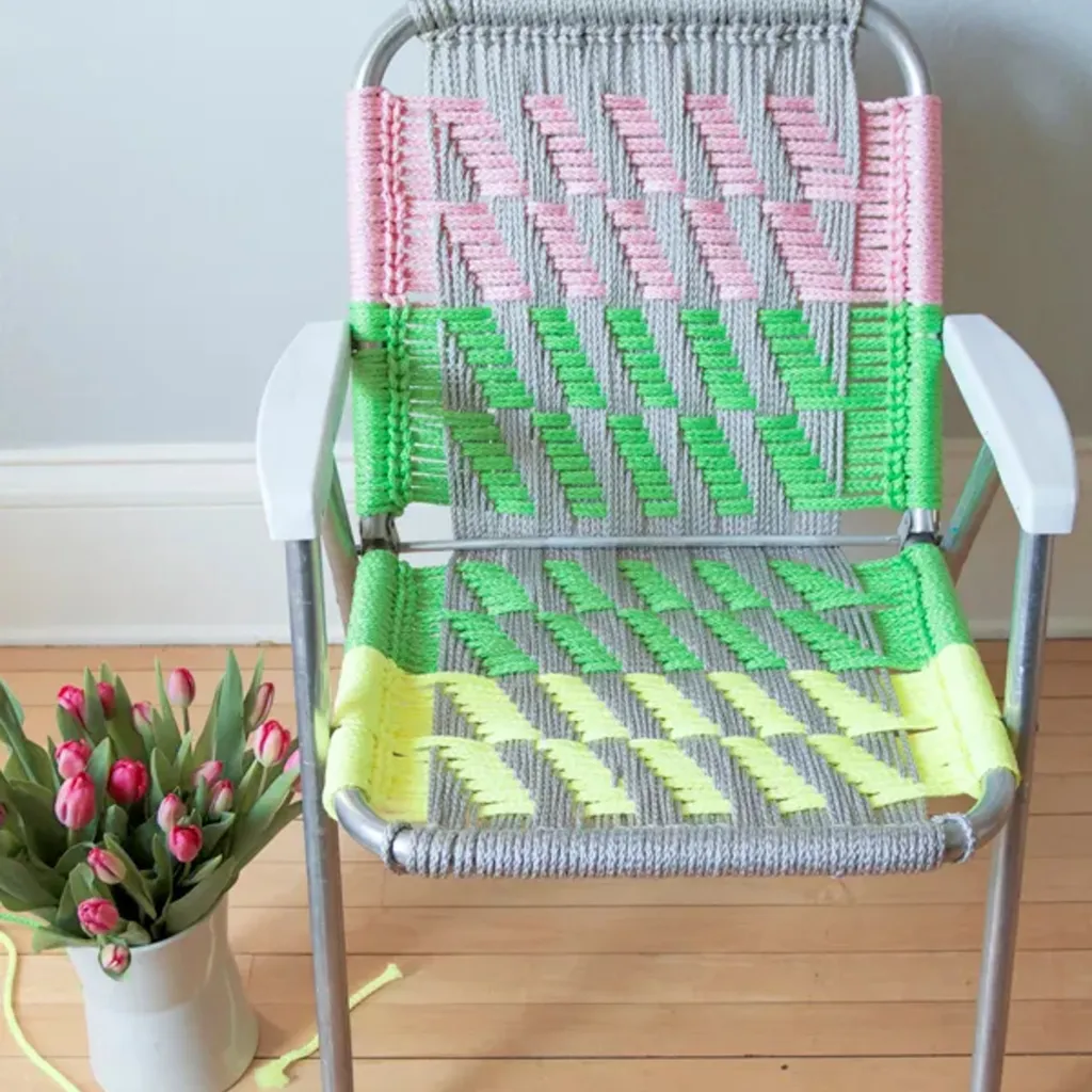 Folding metal chair upcycled with colourful macrame in stripes of yellow, green and pink