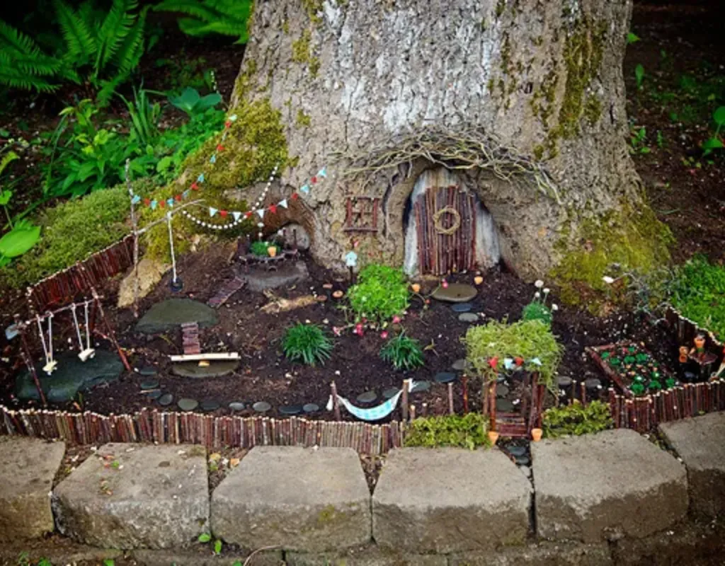 Magical fairy garden with a door set into a tree, a fence, bunting, hammock, swings and plants