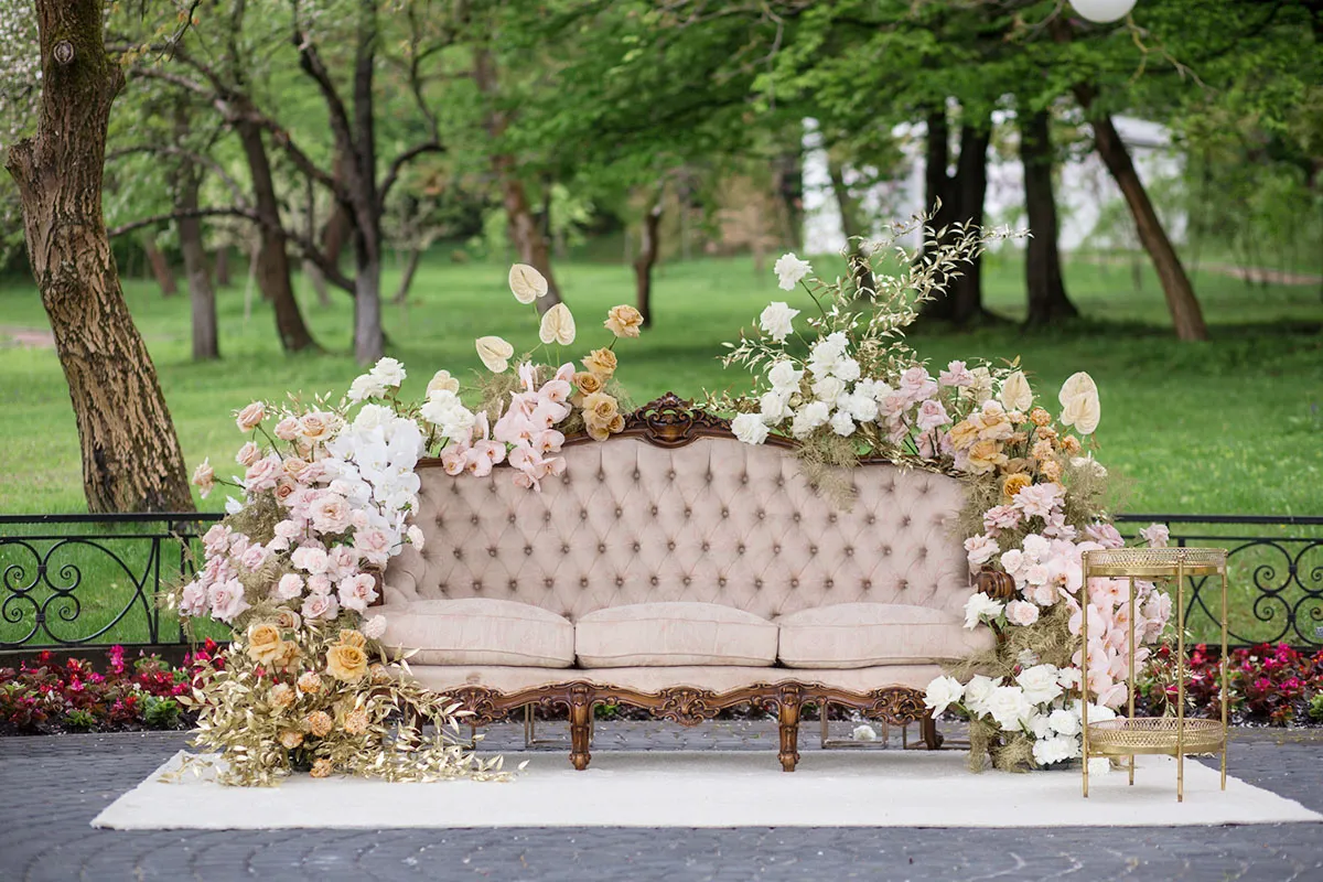 Sofa decorated with flowers at an outdoor wedding