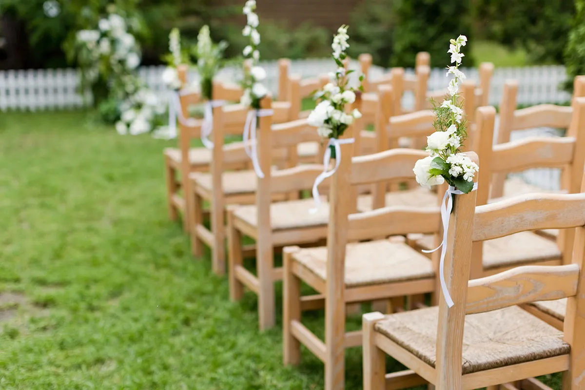 Wooden chairs with flowers at a wedding ceremony