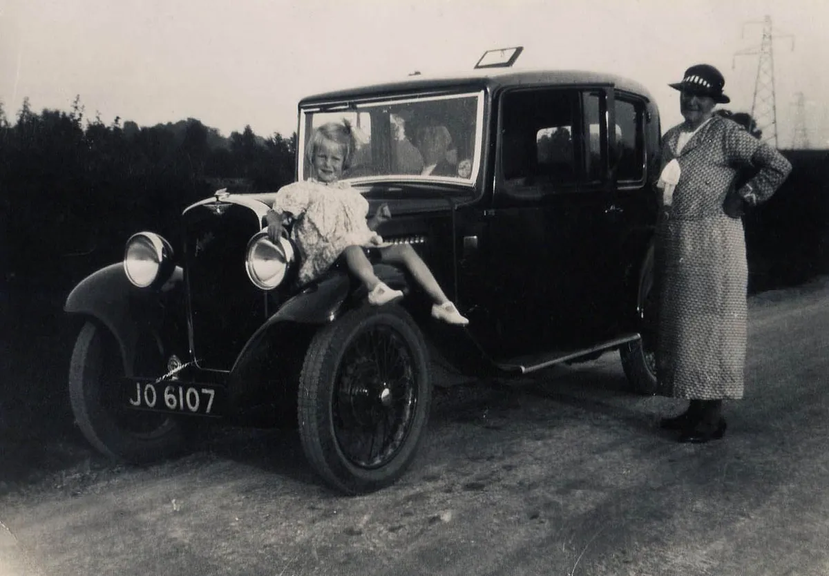 Young Jean Mundy sitting on a car