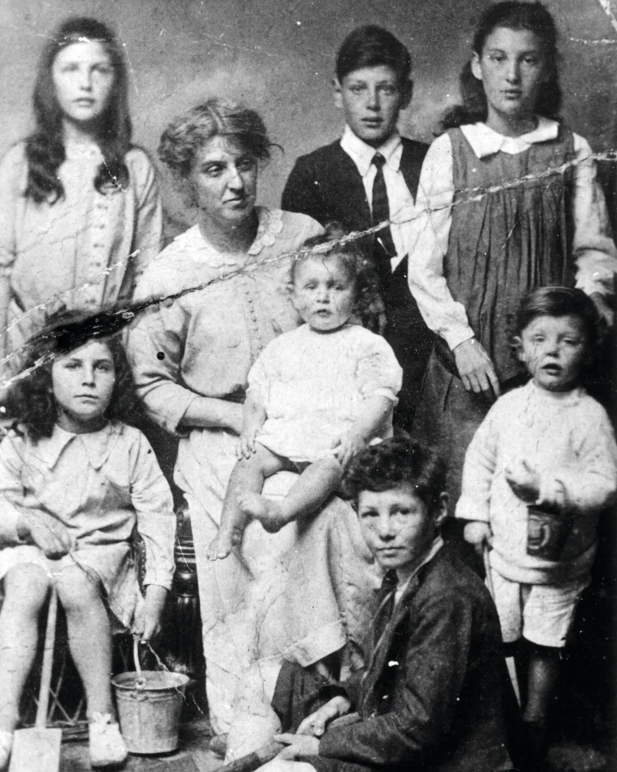 Black and white photograph of a woman and seven children in old-fashioned clothes