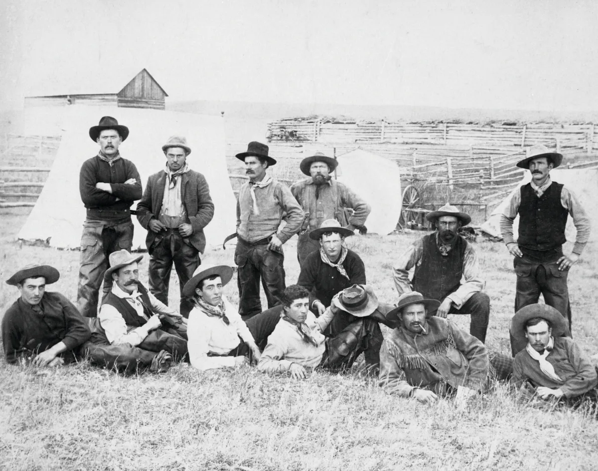 Black and white photograph of a group of cowboys on a ranch