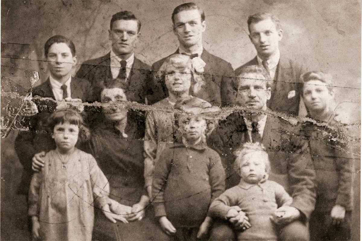Black and white photograph of a couple with nine children - four young men, three little boys and a little girl