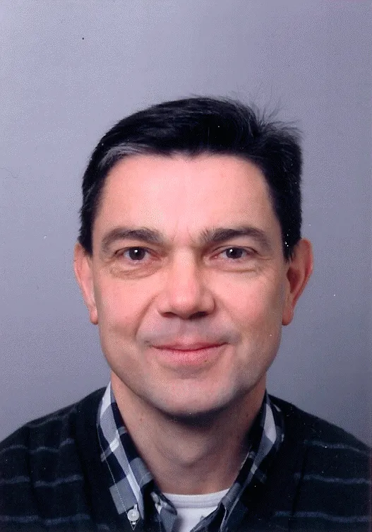 A colour headshot of a white man with black hair
