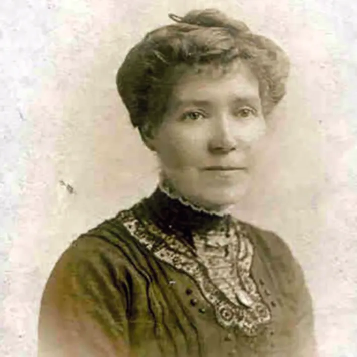 Black and white photograph of a woman in a dark blouse with her hair pinned up