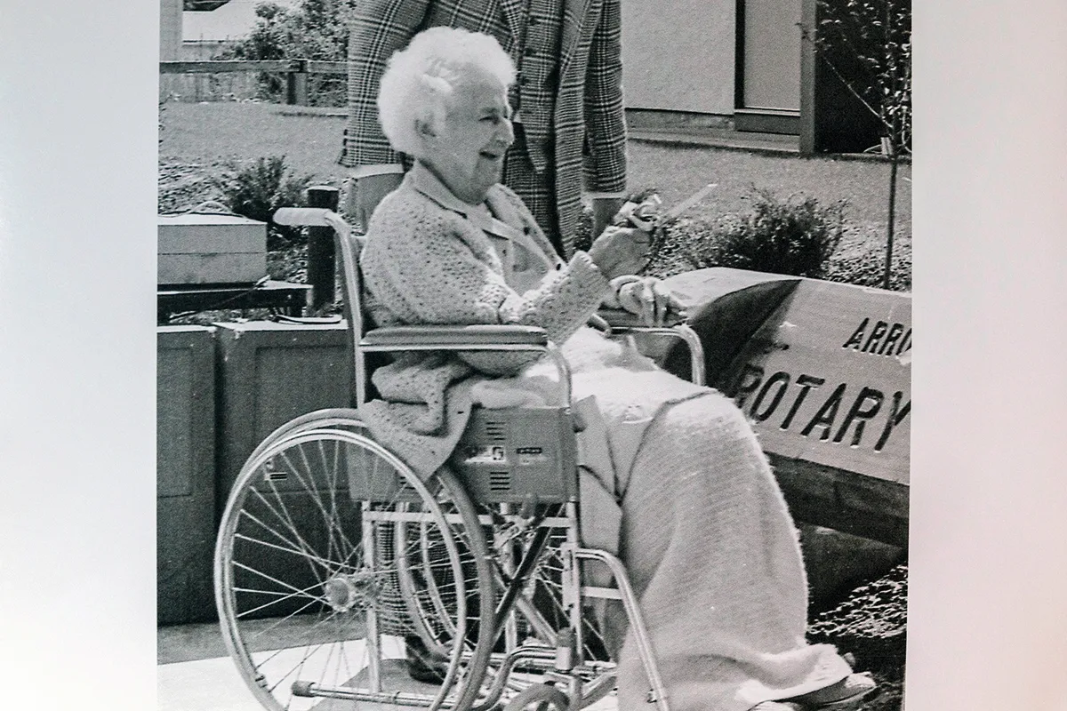 Black and white photograph of an old woman in a wheelchair