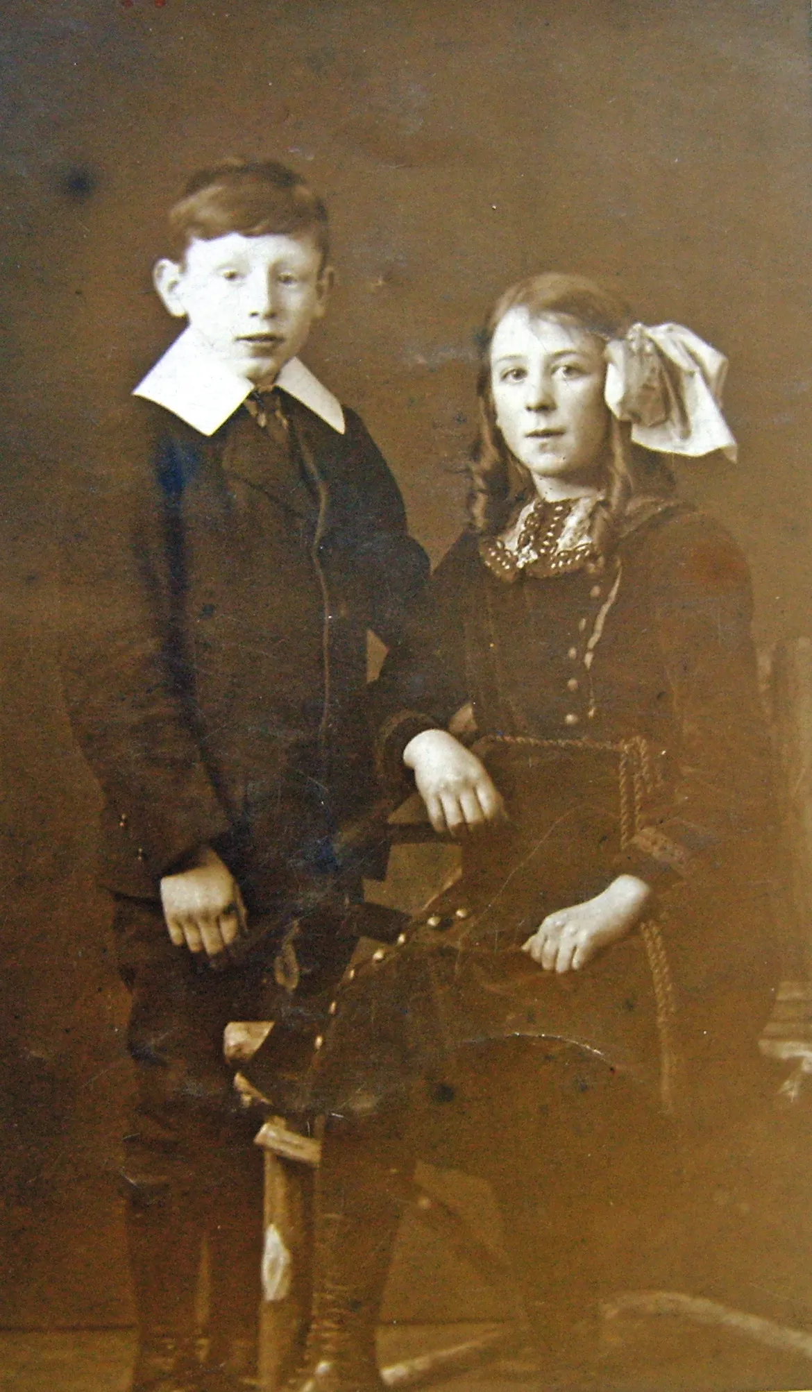 Black and white photograph of a little boy in a suit and a little girl with a bow in her hair.