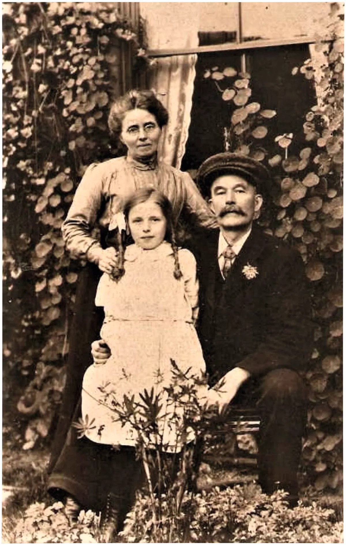 Black and white photograph of a man, a woman and a little girl in Victorian dress