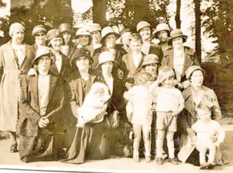Black and white photograph of a group of men, women and children in old-fashioned clothes