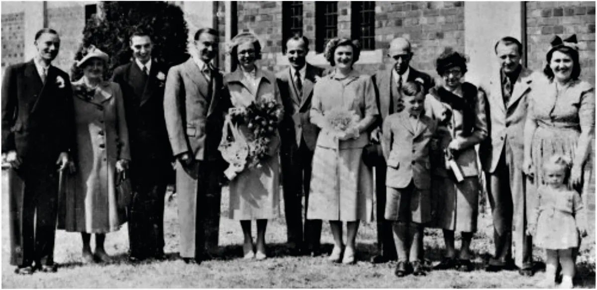 A black and white photograph of a group of people at a wedding