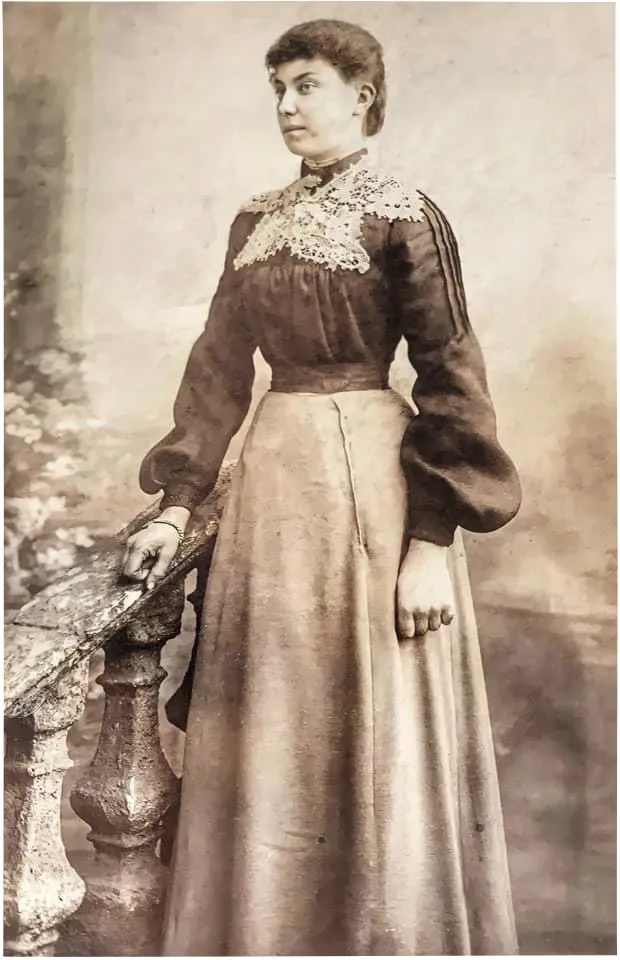 Black and white portrait photograph of a young woman in Victorian dress