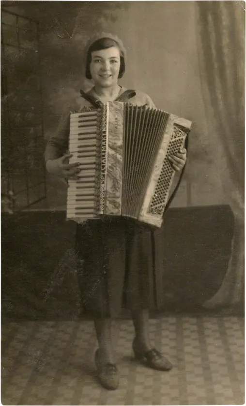 Black and white photograph of a smiling little girl playing an accordion