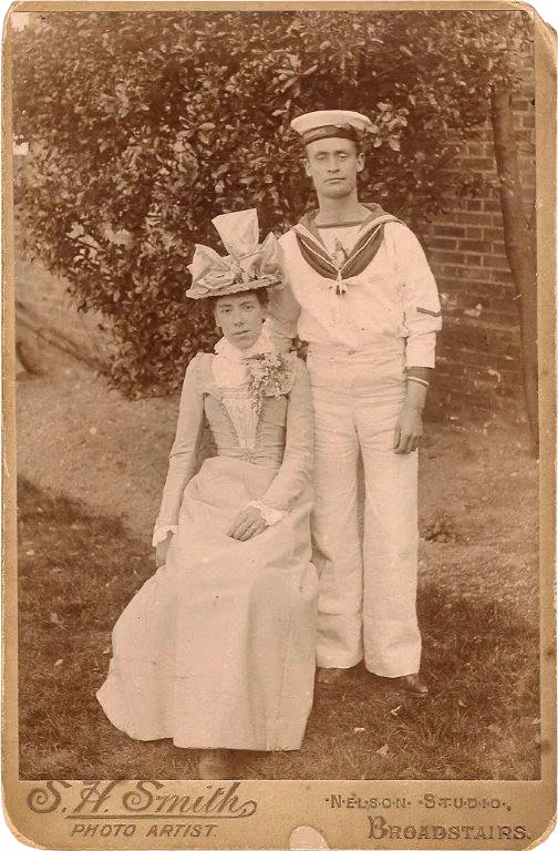 Black and white portrait photograph of a man in a sailor's uniform and a woman in Victorian dress