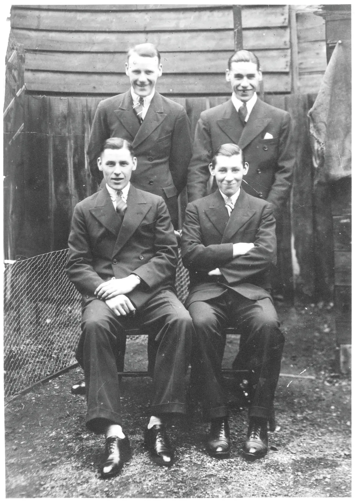 Black and white photograph of four young men in 1940s clothes