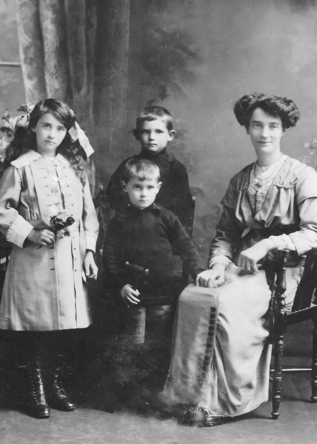 Black and white photograph of a woman, two boys and a girl in Victorian clothes