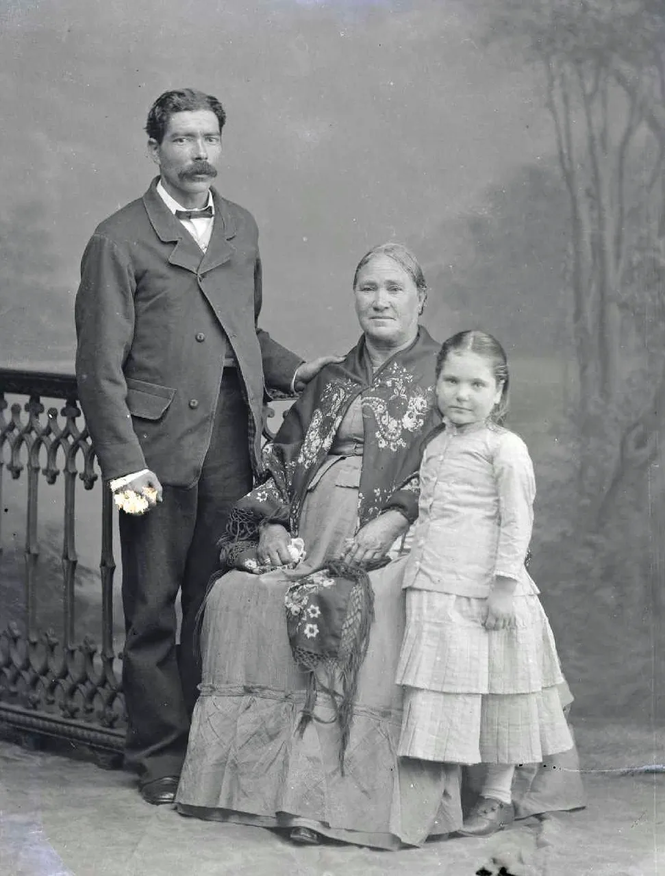 Black and white photograph of a Portugese man, an old woman and a little girl in old-fashioned clothes