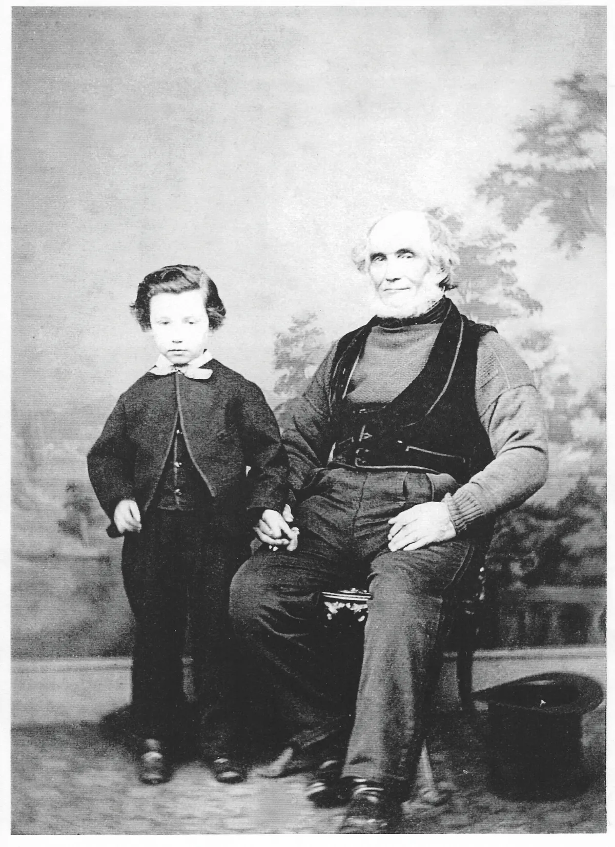 Black and white photograph of an old man with a beard and a little boy in a suit