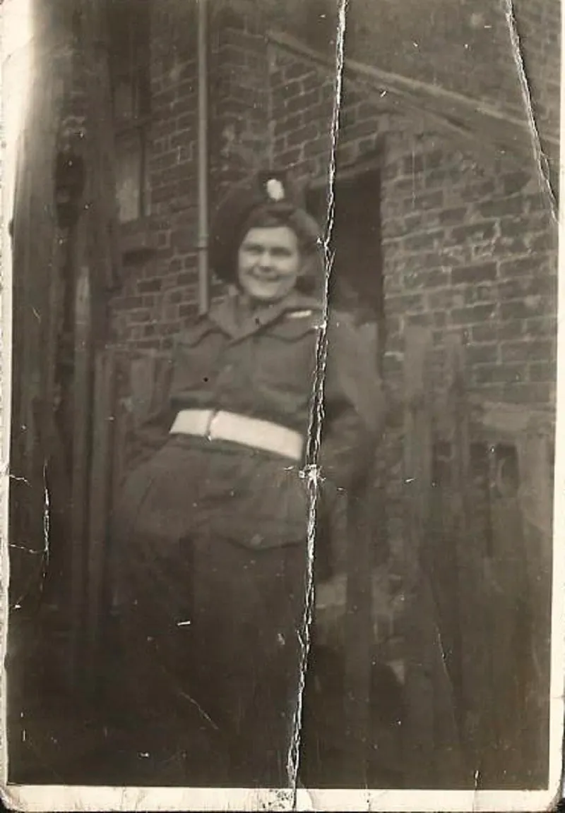 Black and white photograph of a woman wearing a Second World War man's army uniform
