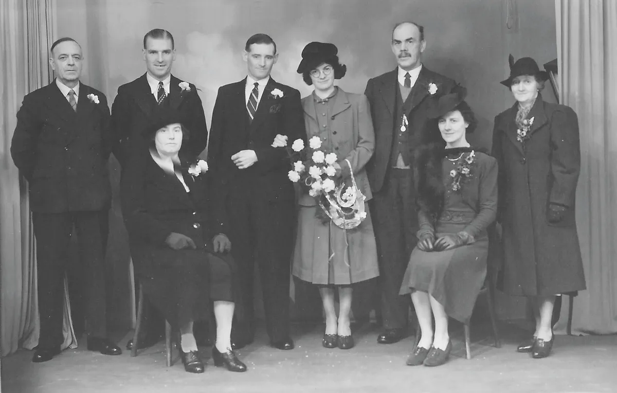 Black and white photograph of a couple getting married in the Second World War, surrounded by their guests