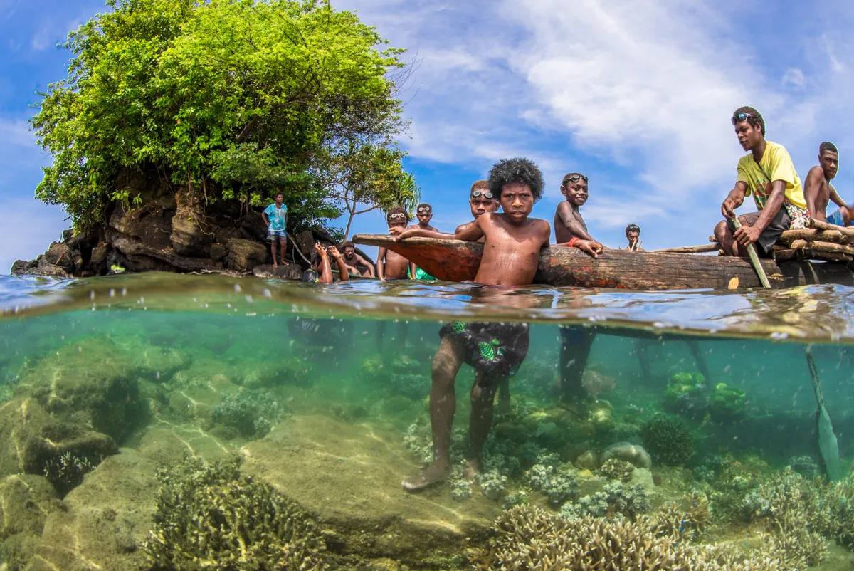 Coastal Community: Local boys gather in front of a small mangrove-associated outcropping along the coast of Papua New Guinea. Coastal ecosystems here rely on a community-based system of conservation and protection; the local people value their ecosystems and protect them as such. © Morgan Bennett-Smith, Papua New Guinea