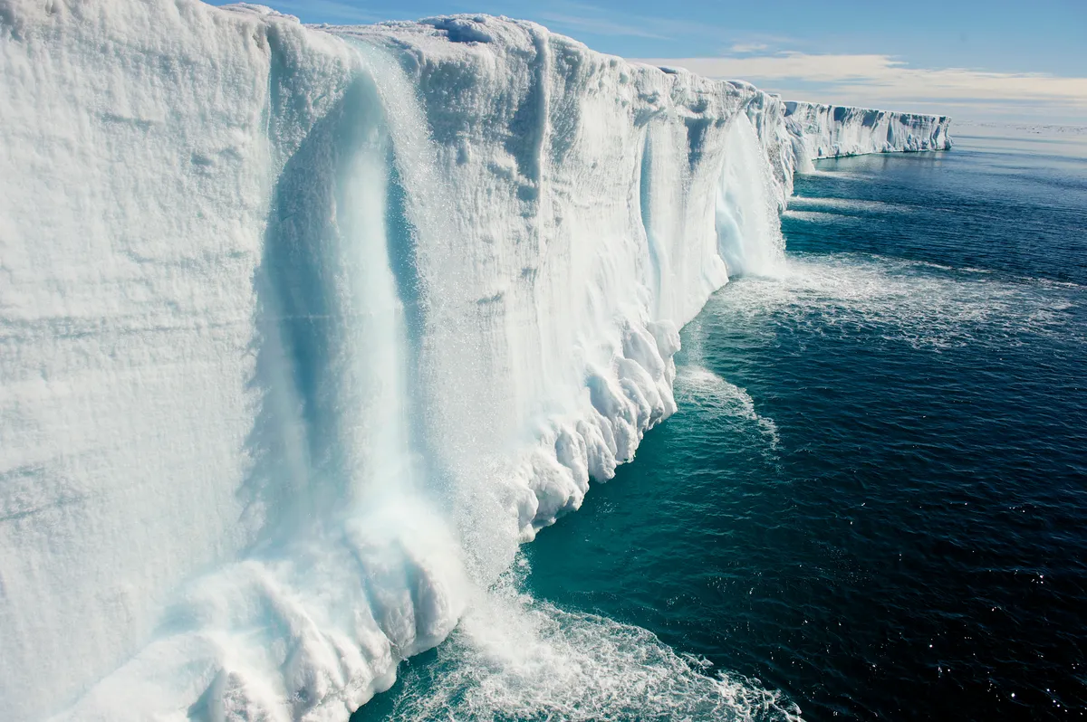 Waterfalls cascade to the sea from a melting icecap. © Keen Press/Getty