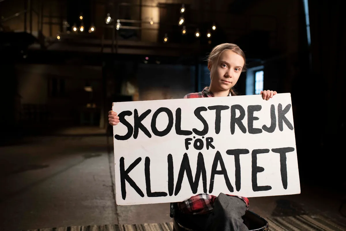 Greta Thunberg with her striking sign, which translates to: School Strike for the Climate. © Banfa Jawla/BBC Studios