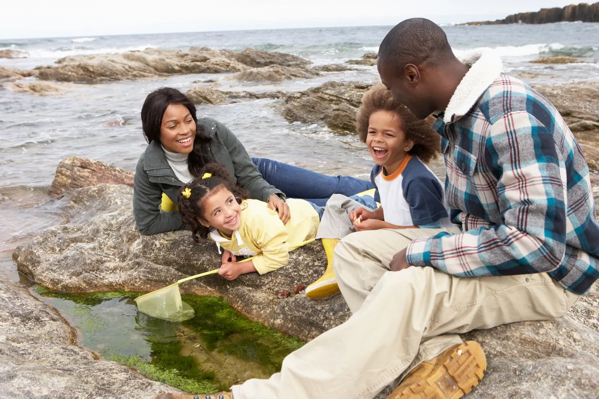 A family rockpooling. © omgimages/Getty